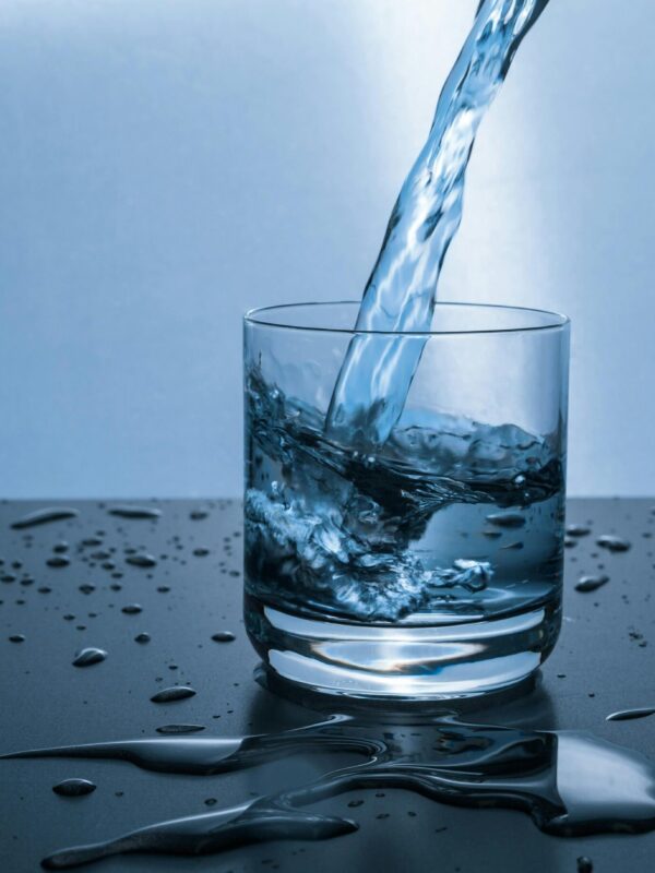 High-quality image of water being poured into a glass, illustrating hydration purity. and proone water filter