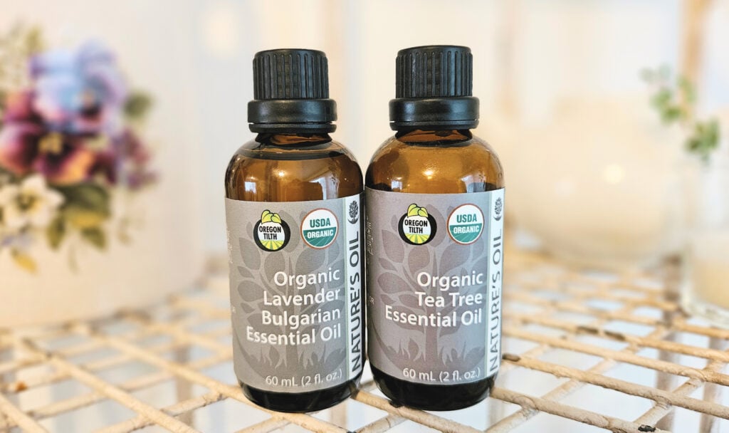 Two brown glass bottles of essential oils. One is lavender and one is tea tree.