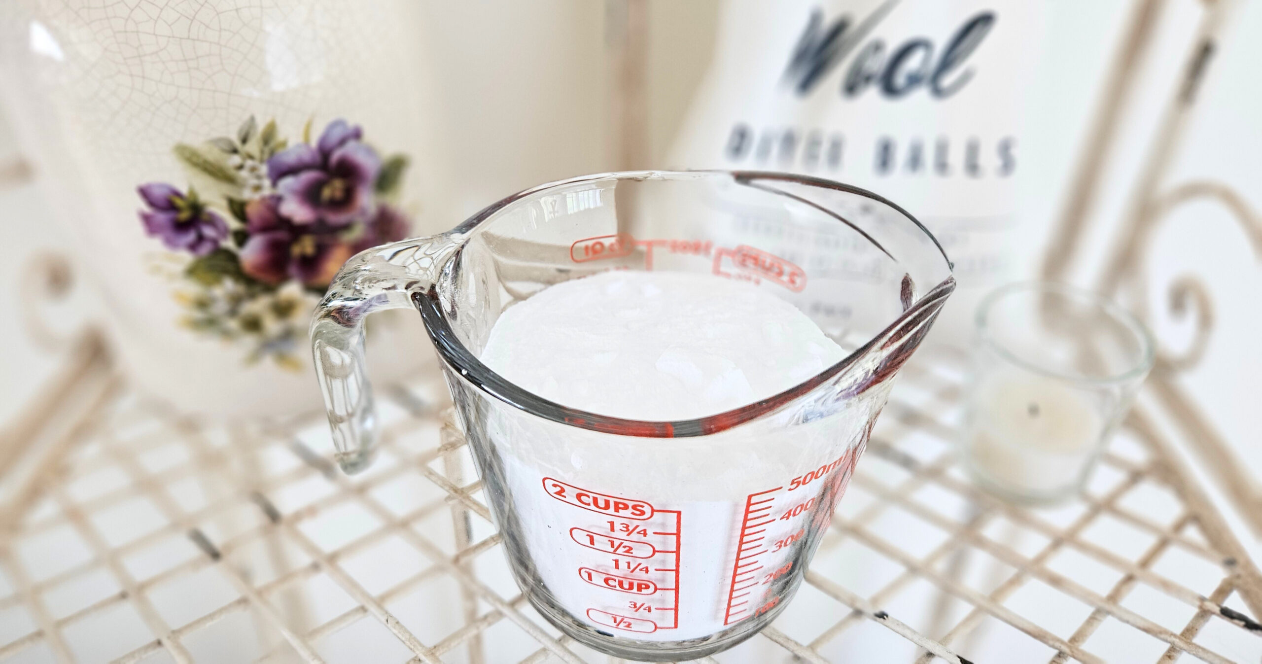 A glass measuring cup filled with two cups of baking soda. Baking soda is a white powdery mixture.