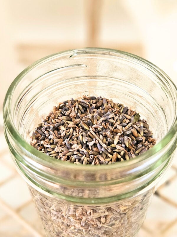 Glass mason jar filled with dried lavender flowers.
