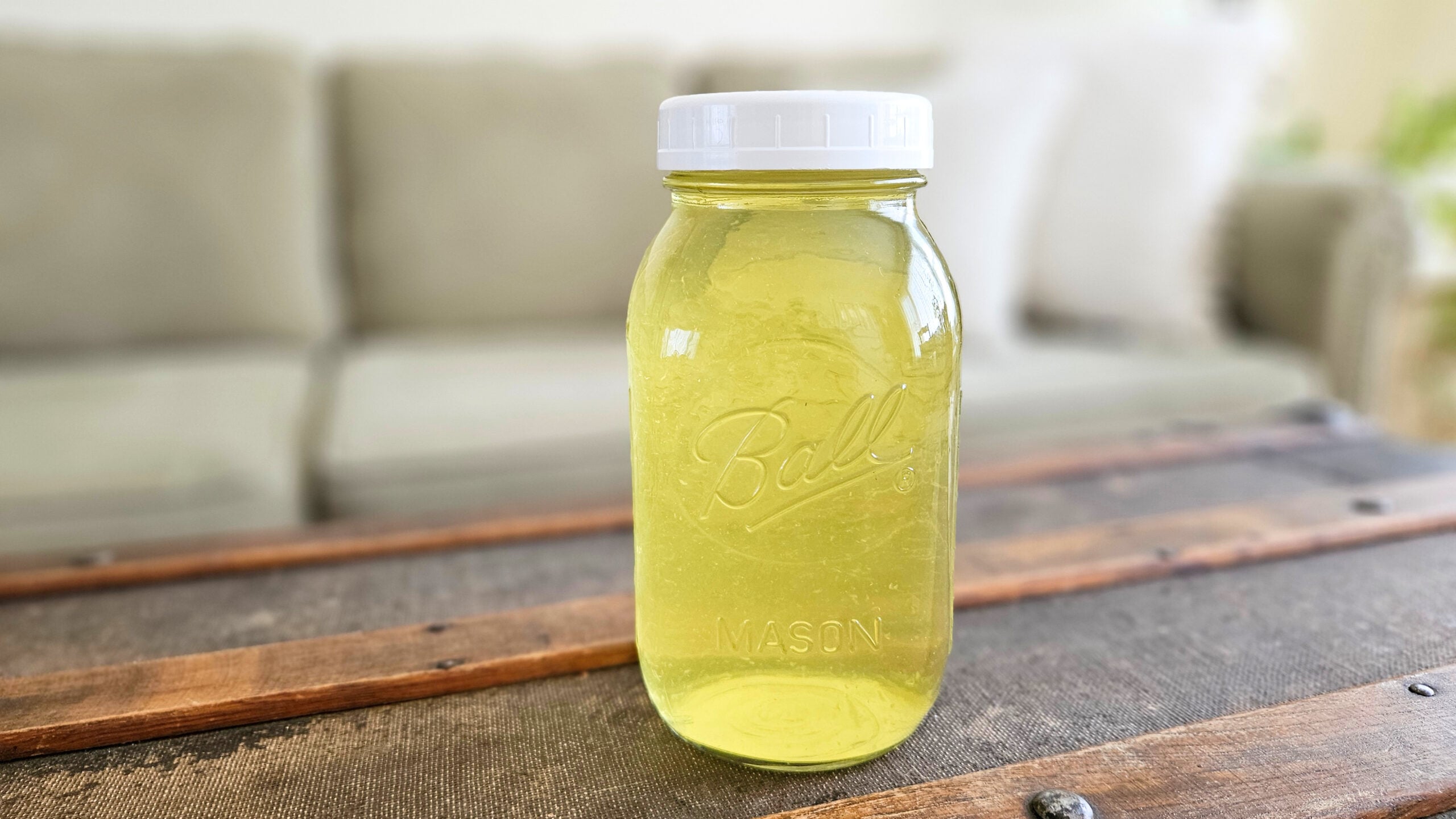 Quart size mason jar of yellow liquid fabric softener.