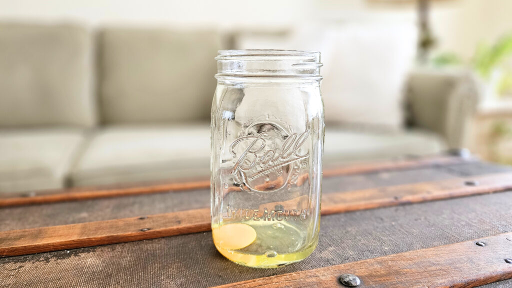Quart size mason jar with one raw egg.