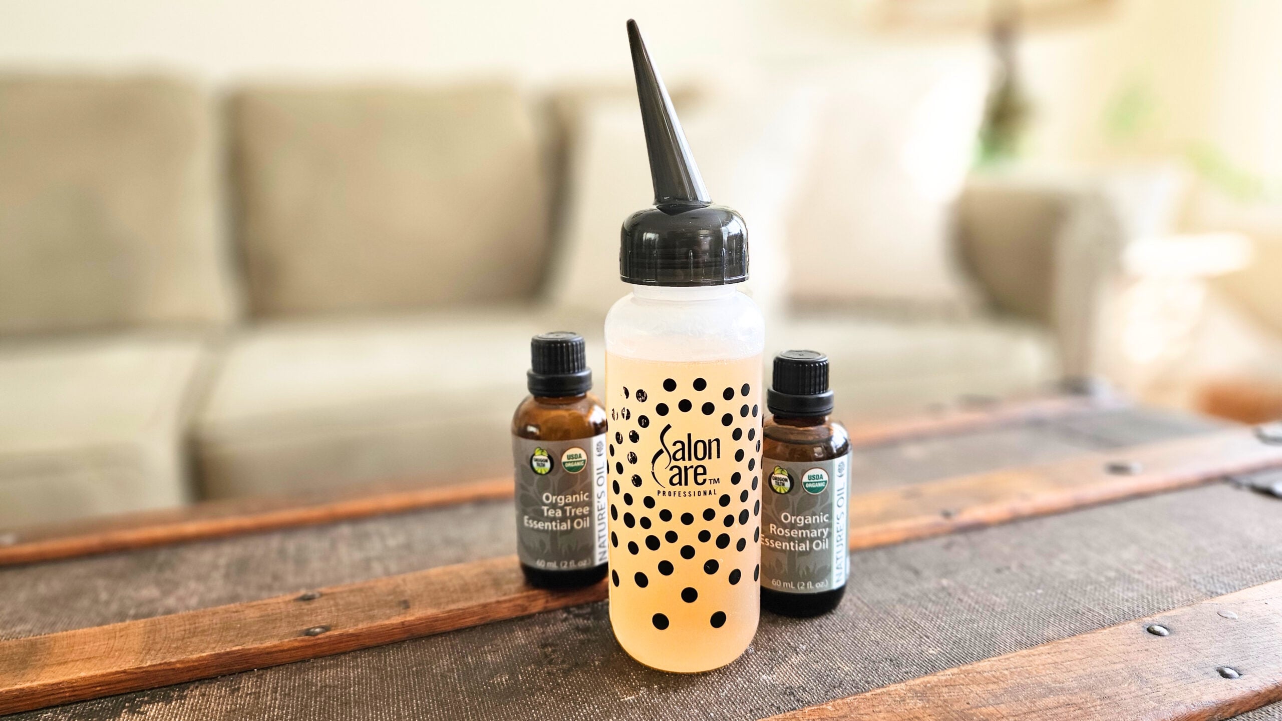 Bottle of apple cider vinegar hair and scalp rinse with two bottles of essential oils.