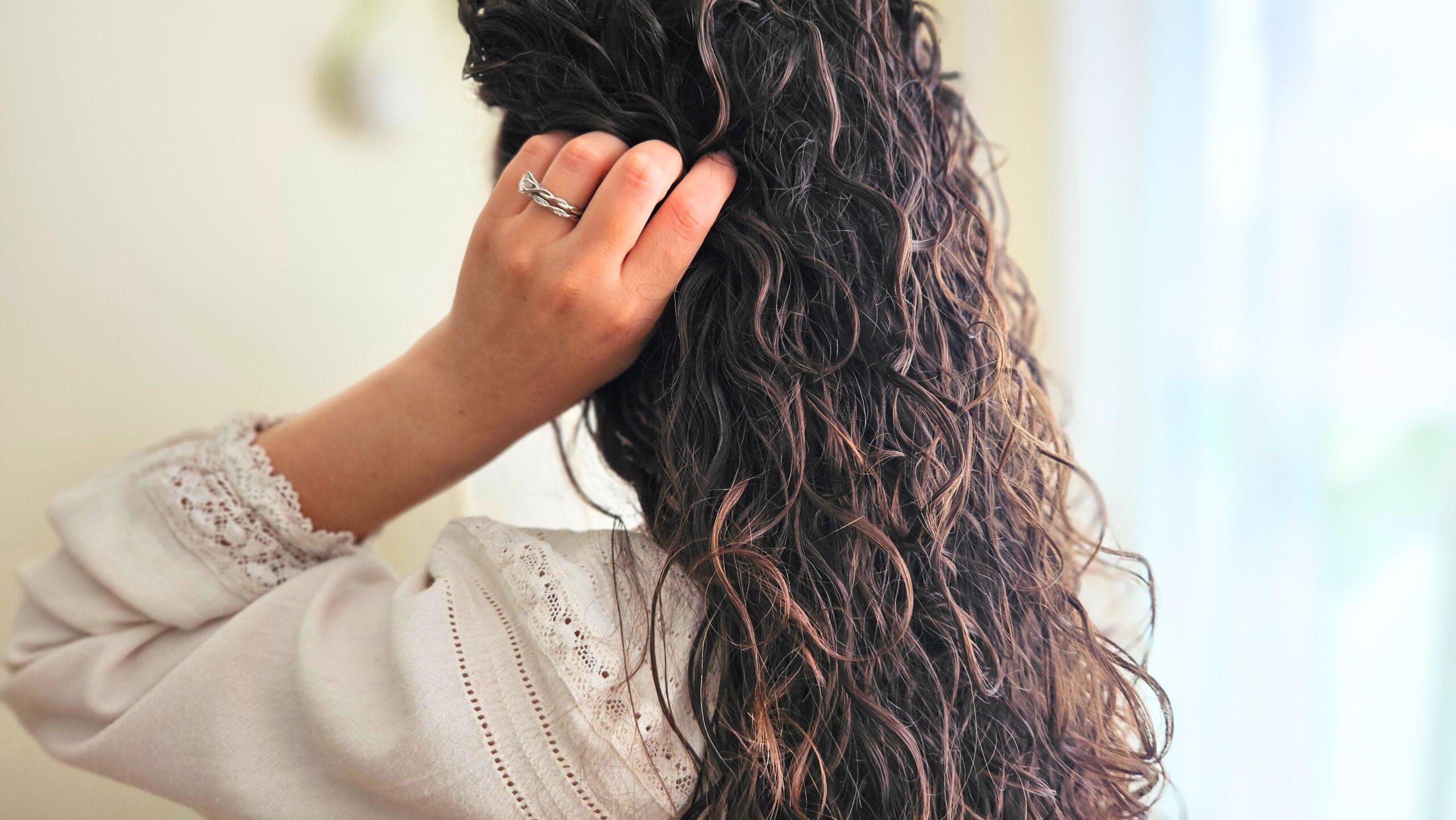 Woman with curly hair after using apple cider vinegar hair and scalp rinse.